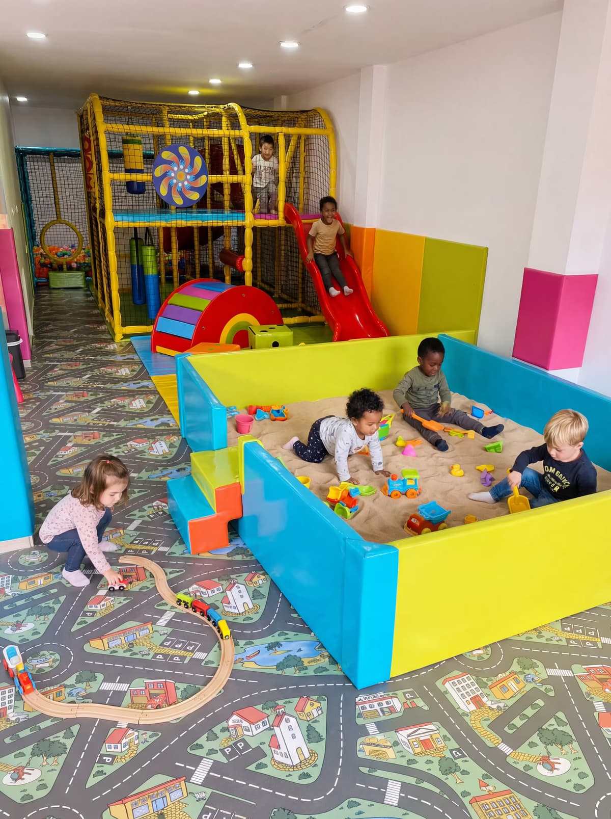 Vista interior del moderno parque de soft play Pequeplay con diseños arquitectónicos seguros e iluminación cálida